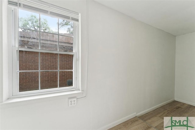 unfurnished room with baseboards and wood finished floors