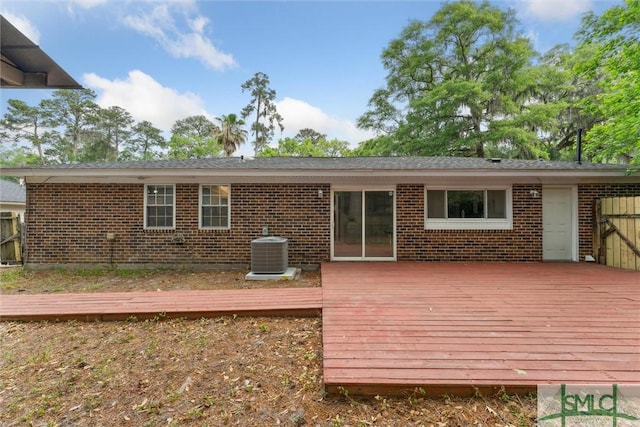 back of house featuring brick siding, a wooden deck, and central air condition unit