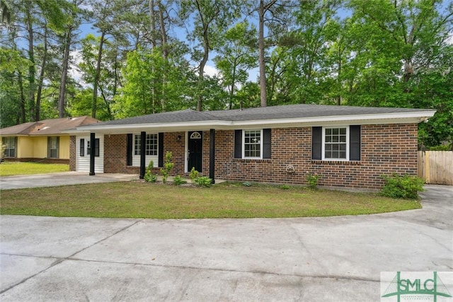 single story home with concrete driveway, fence, a front yard, and brick siding