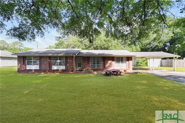 single story home featuring fence, an attached carport, brick siding, and a front yard