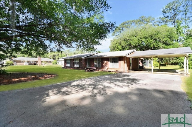 ranch-style house with driveway, a front yard, and a carport