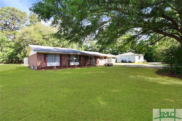 single story home featuring brick siding and a front yard