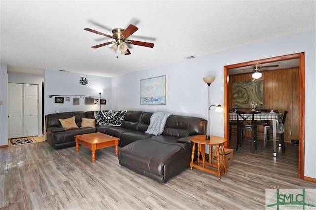 living area featuring a ceiling fan, visible vents, and light wood-style flooring