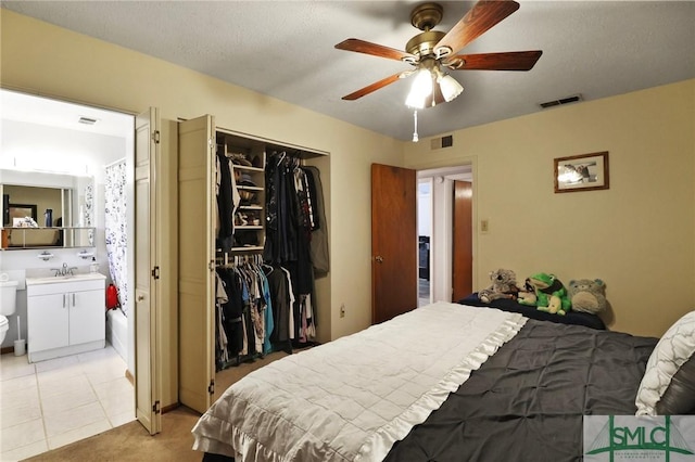 bedroom with visible vents, a sink, ensuite bathroom, and a closet