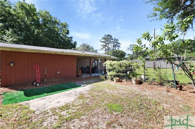 back of house with board and batten siding and fence