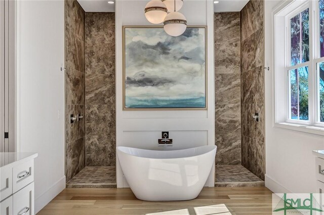 31 Tivoli Ln, Richmond Hill, GA 31324 - full bath featuring a walk in shower, wood finished floors, vanity, and a freestanding bath