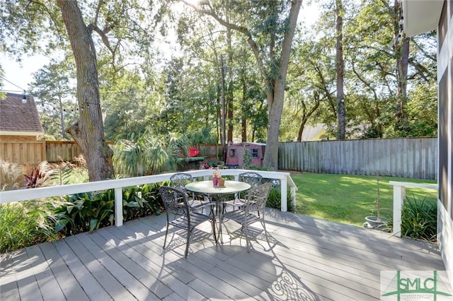 8 Baker Dr, Savannah, GA 31410 - deck with an outdoor structure, a fenced backyard, a lawn, a storage shed, and outdoor dining space