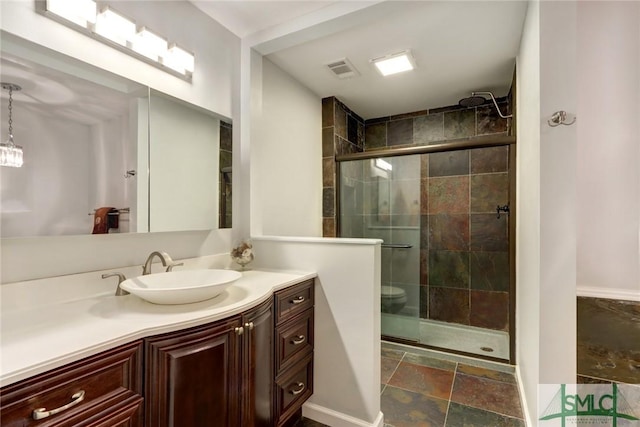 8 Baker Dr, Savannah, GA 31410 - bathroom featuring stone finish floor, visible vents, a stall shower, vanity, and baseboards
