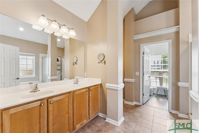 bathroom featuring baseboards, tile patterned flooring, double vanity, and a sink