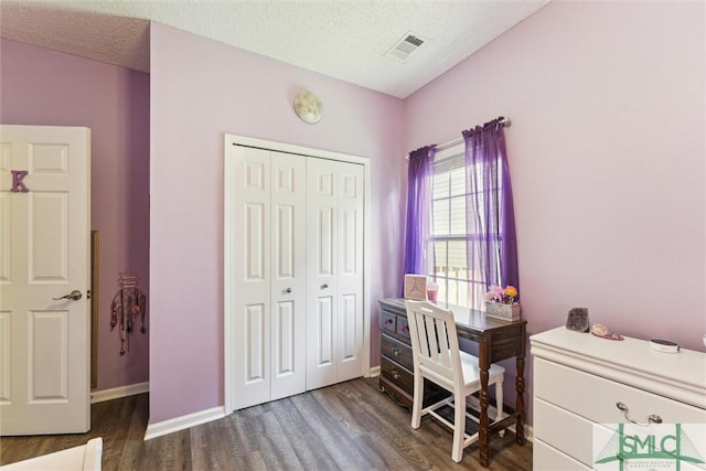 interior space featuring dark wood-type flooring, visible vents, baseboards, and a textured ceiling