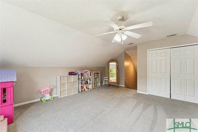 playroom featuring lofted ceiling, visible vents, baseboards, carpet, and a ceiling fan