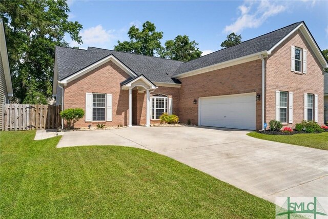 125 Blue Lake St, Richmond Hill, GA 31324 - view of front facade featuring brick siding, fence, concrete driveway, a front yard, and a gate