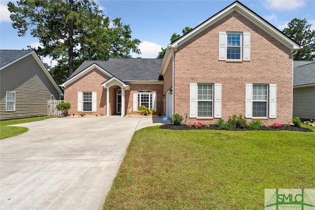 125 Blue Lake St, Richmond Hill, GA 31324 - view of front of property featuring concrete driveway, a front lawn, and brick siding