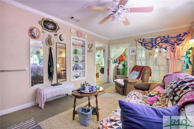 sitting room featuring carpet flooring, baseboards, visible vents, a ceiling fan, and crown molding