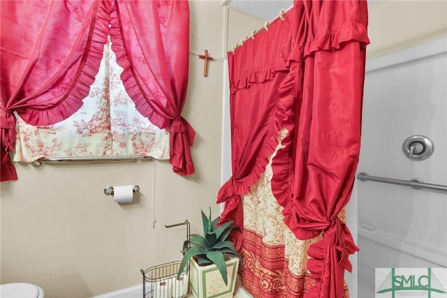 bathroom with toilet and a shower with shower curtain