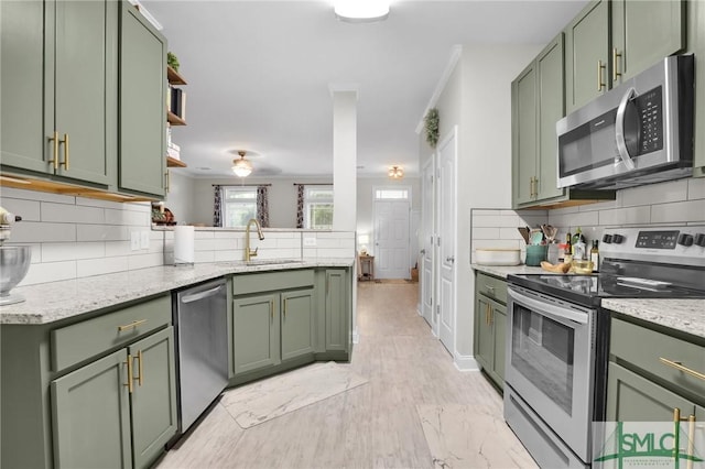 kitchen featuring green cabinetry, stainless steel appliances, and tasteful backsplash