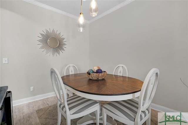 dining area with ornamental molding, wood finished floors, and baseboards