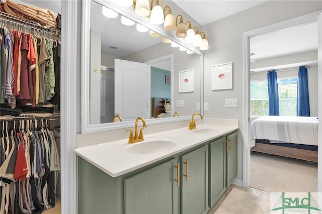 full bathroom with a walk in closet, double vanity, a sink, and ensuite bath