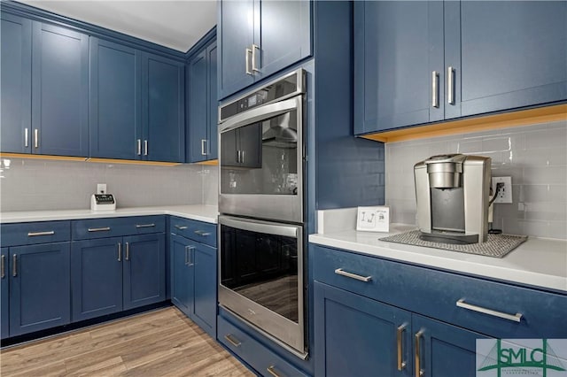 21 Shoefstall St, Savannah, GA 31407 - kitchen featuring blue cabinets, stainless steel double oven, and tasteful backsplash