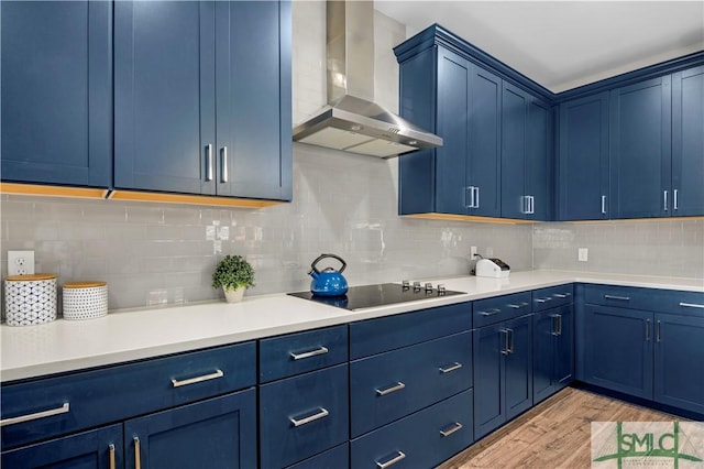 21 Shoefstall St, Savannah, GA 31407 - kitchen featuring wall chimney range hood, light wood-style flooring, blue cabinetry, and black electric stovetop