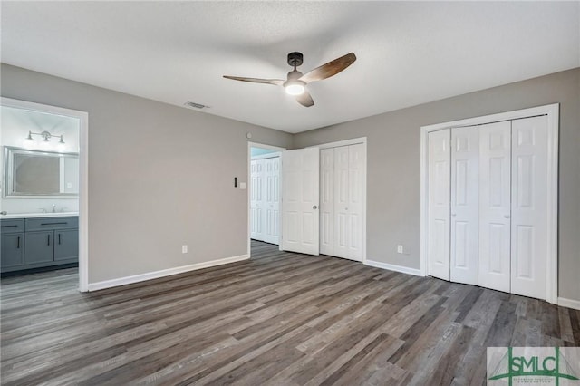 4 Quail Trl, Savannah, GA 31406 - unfurnished bedroom with baseboards, a sink, wood finished floors, and two closets