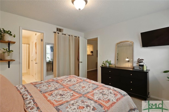 401 N Cromwell Rd Unit P-5, Savannah, GA 31410 - bedroom featuring visible vents, a textured ceiling, and ensuite bath