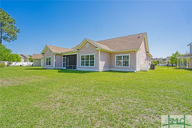 23 Olde Gate Ct, Pooler, GA 31322 - rear view of house featuring a lawn, a sunroom, central AC unit, and roof with shingles