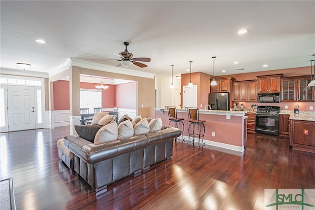 23 Olde Gate Ct, Pooler, GA 31322 - living room with dark wood finished floors, a ceiling fan, a chandelier, ornamental molding, and wainscoting