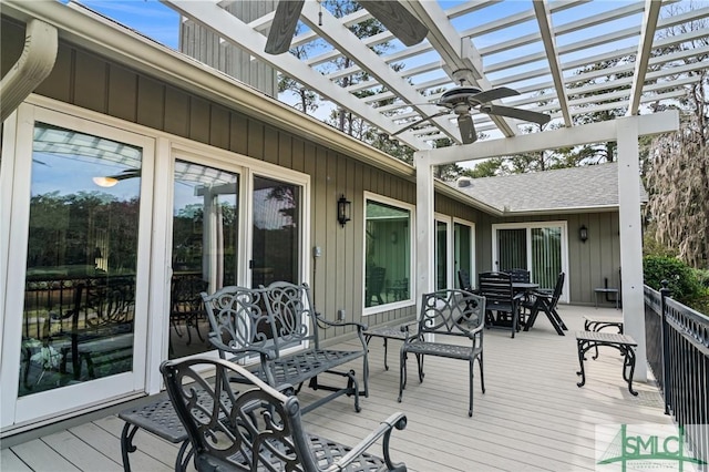 deck featuring a ceiling fan, a pergola, and outdoor dining space