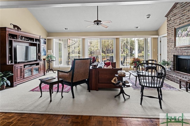 living room featuring visible vents, a fireplace, a ceiling fan, and lofted ceiling
