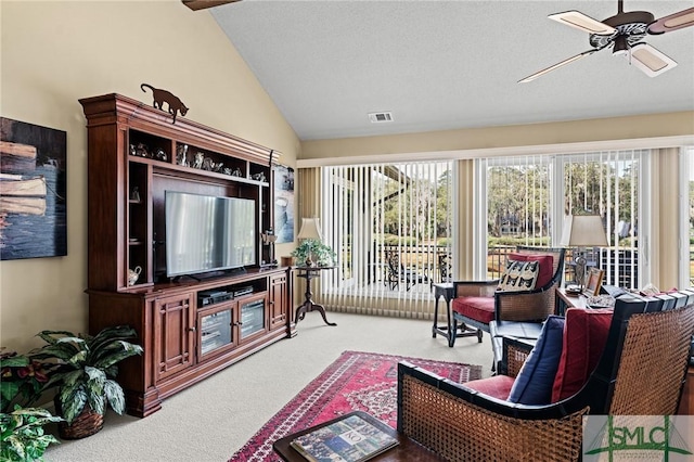 carpeted living room featuring visible vents, ceiling fan, and lofted ceiling