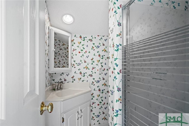 bathroom with vanity and wallpapered walls