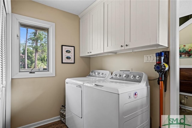 clothes washing area featuring baseboards, cabinet space, and washer and dryer