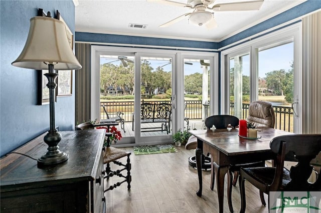 sunroom / solarium featuring visible vents, ornamental molding, and wood-type flooring