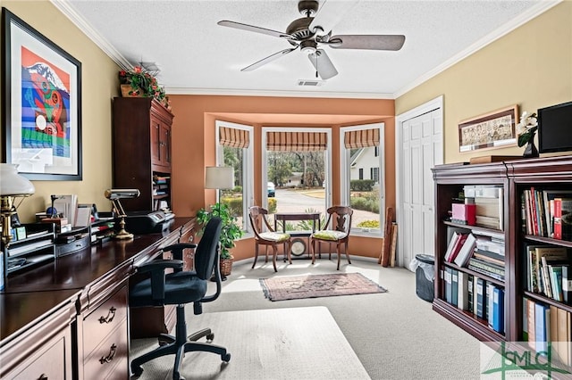 carpeted office space with crown molding, ceiling fan, a textured ceiling, and visible vents