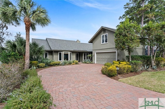 traditional home with an attached garage and decorative driveway