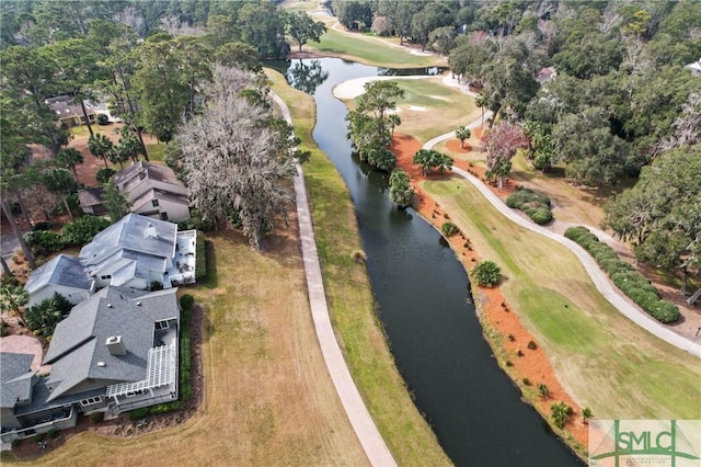drone / aerial view with view of golf course and a water view