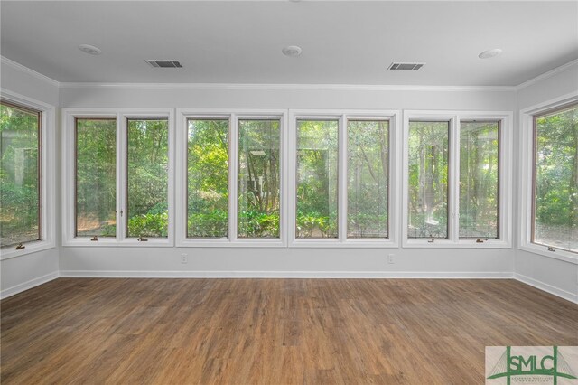 unfurnished sunroom featuring visible vents, baseboards, and wood finished floors