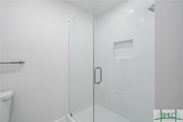 full bathroom featuring a stall shower and toilet