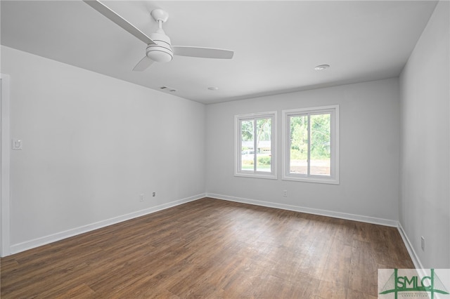 unfurnished room with a ceiling fan, baseboards, visible vents, and dark wood-type flooring