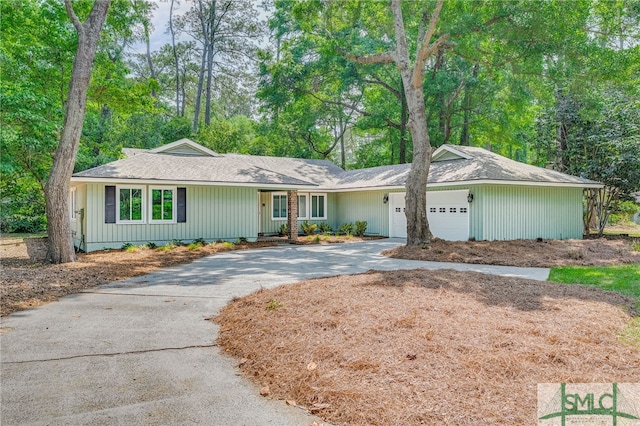 ranch-style home featuring a garage and concrete driveway