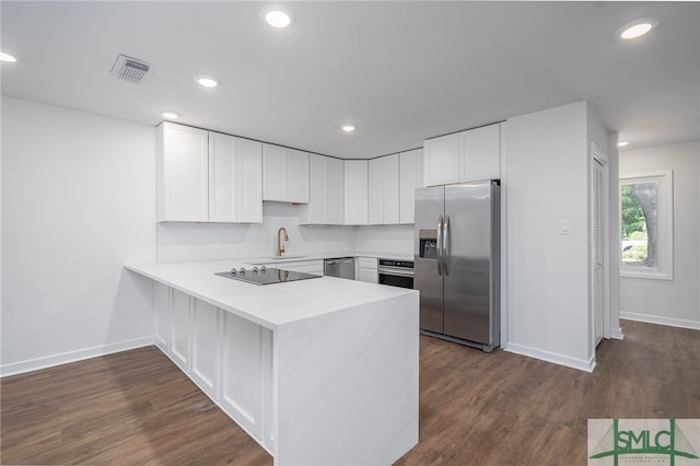 kitchen with stainless steel appliances, baseboards, visible vents, and a peninsula