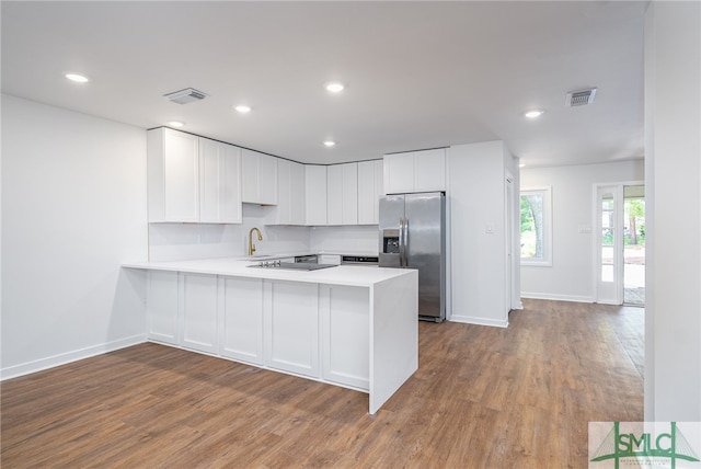 kitchen featuring visible vents, light countertops, wood finished floors, and stainless steel fridge with ice dispenser