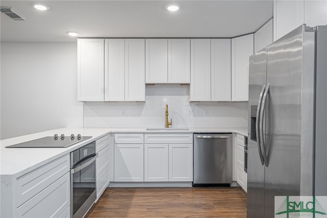 kitchen with white cabinets, stainless steel appliances, visible vents, and a sink