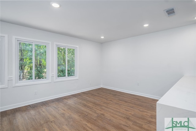spare room with recessed lighting, baseboards, dark wood-style flooring, and visible vents