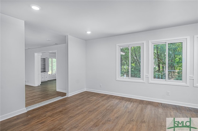 unfurnished room with recessed lighting, baseboards, and dark wood finished floors