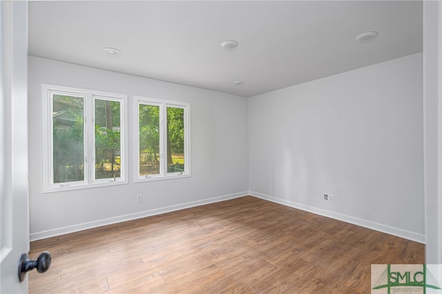 spare room featuring baseboards and wood finished floors