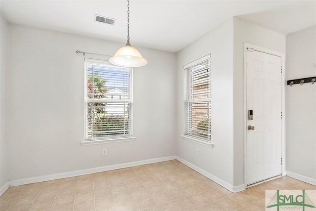 unfurnished dining area with baseboards and visible vents