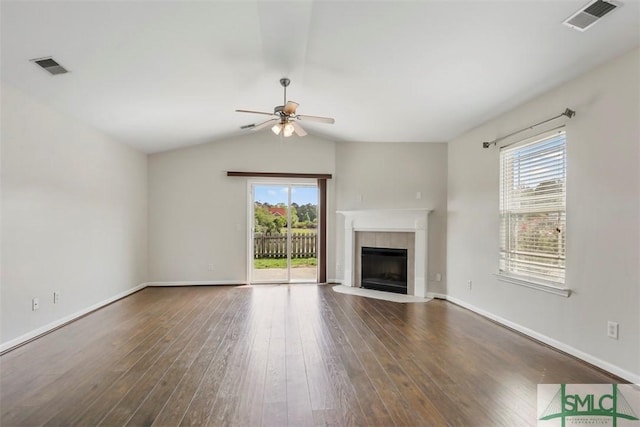 unfurnished living room featuring a ceiling fan, visible vents, a wealth of natural light, and wood finished floors