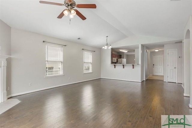 unfurnished living room featuring visible vents, dark wood finished floors, ceiling fan with notable chandelier, and lofted ceiling